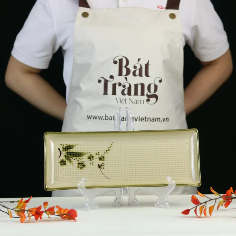 lòng đĩa nền kem, vân ô và nhánh trúc lệch bên.